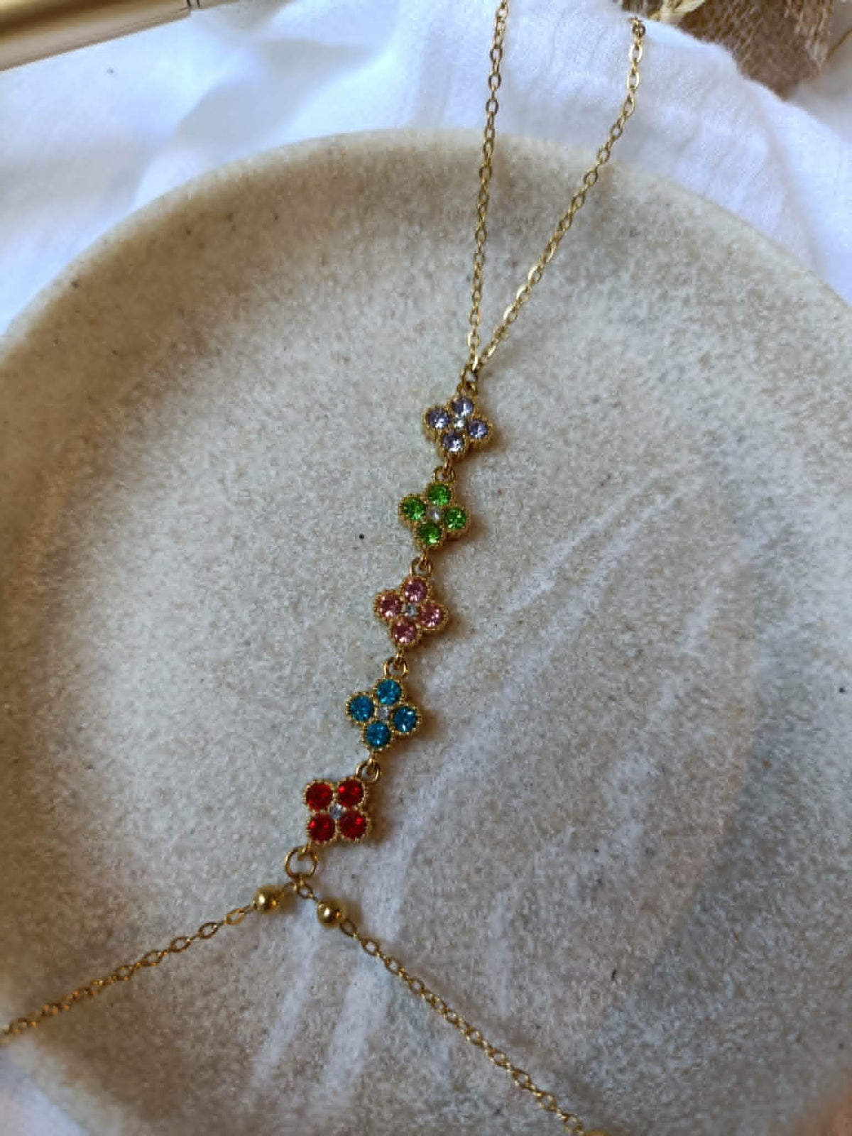 Détail du bracelet de main doré à trèfles