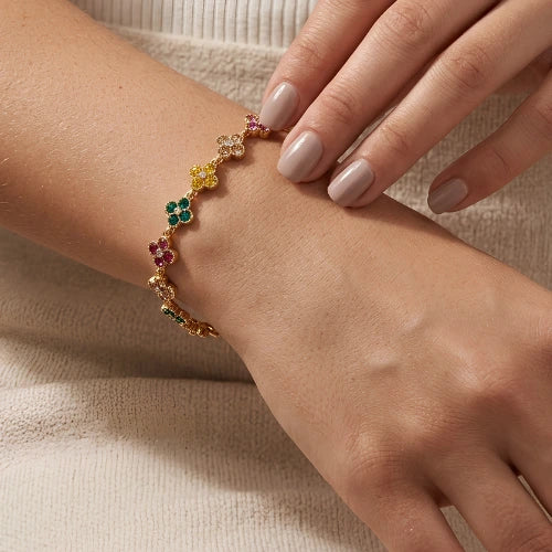 bracelet à trefles multi colors strass sur chaine dorée en acier inoxydable porté au poignet d'une femme