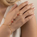 Bracelet de main doré à trèfles rouge porté