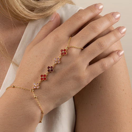 Bracelet de main doré à trèfles rouge porté