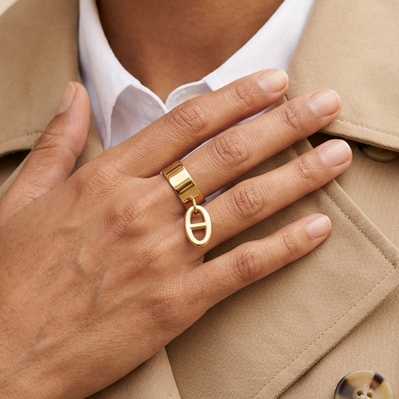 Bague ajustable dorée avec breloque maille marine portée au doigt