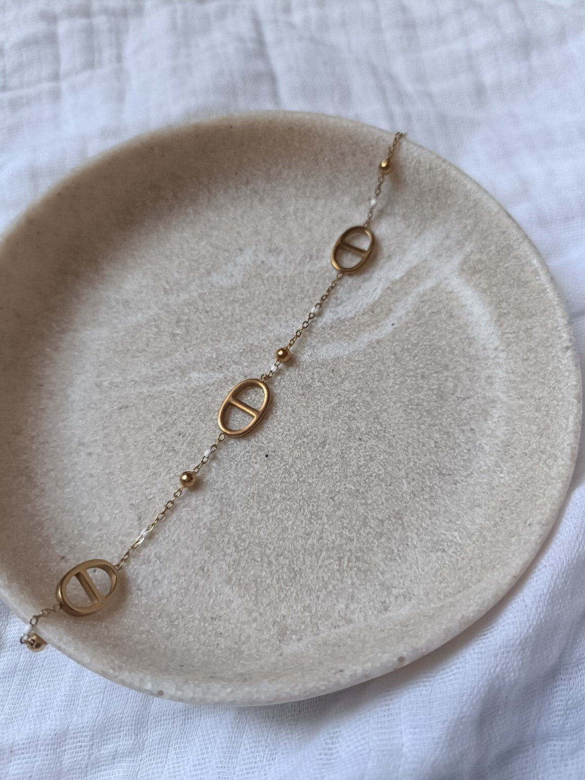 Bracelet doré à mailles marines avec petites perles décoratives, vue à plat