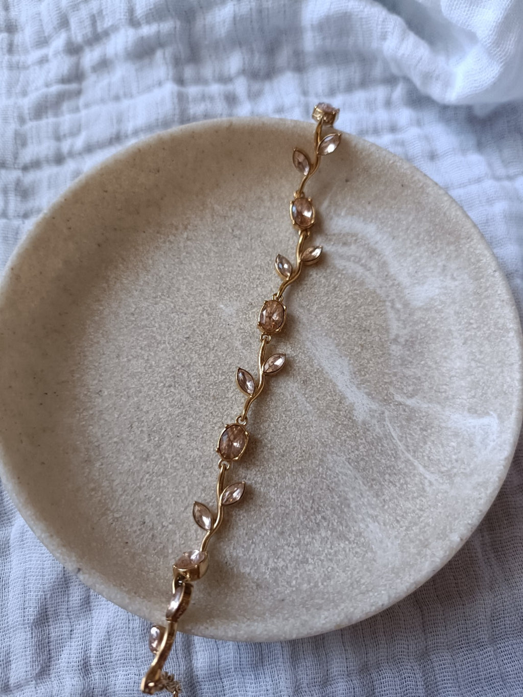 Bracelet tulipe doré en acier inoxydable avec pierres nude rosées, vue à plat