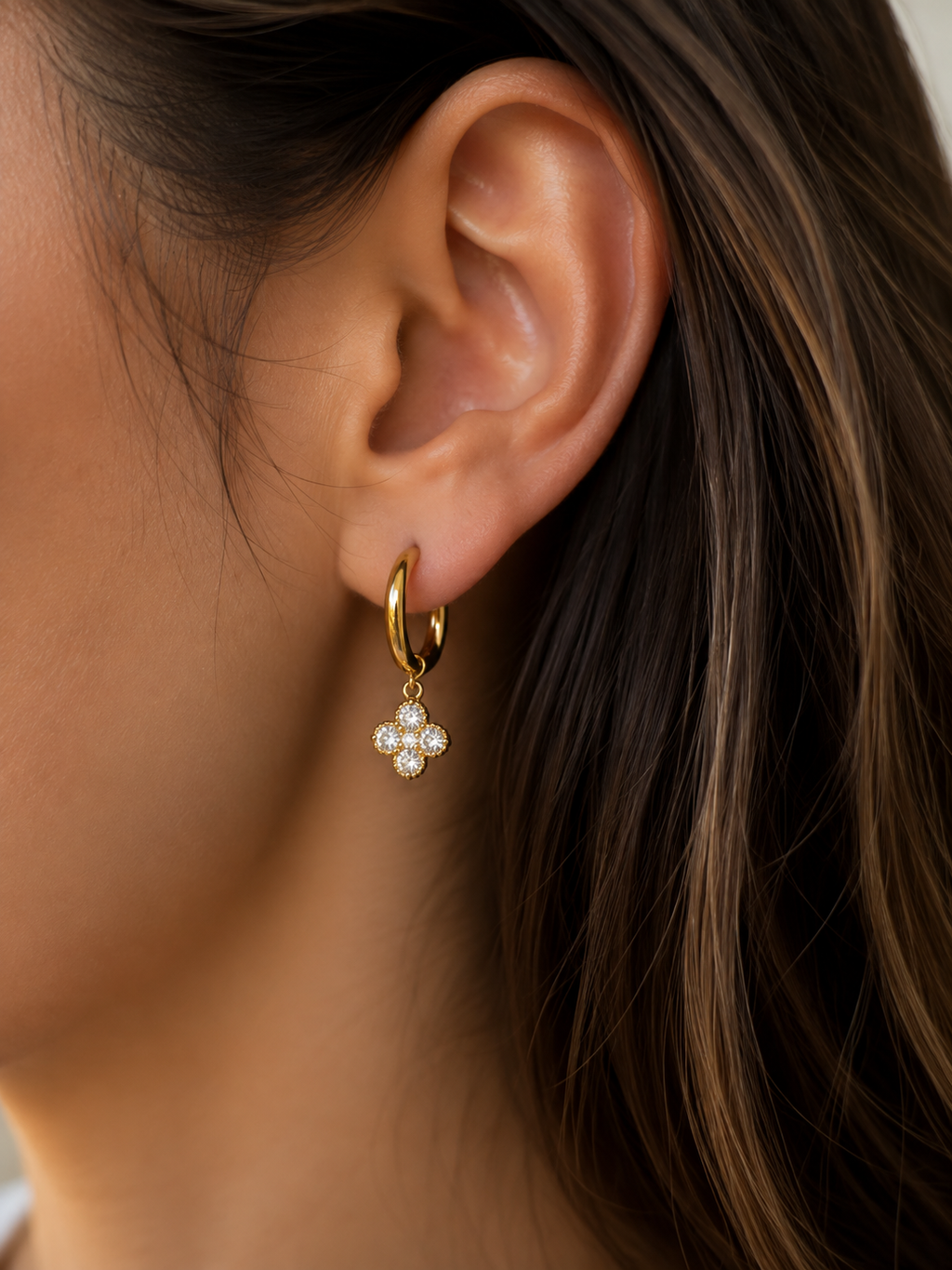 Boucles d'oreilles Trèfle dorées blanches portées par une femme
