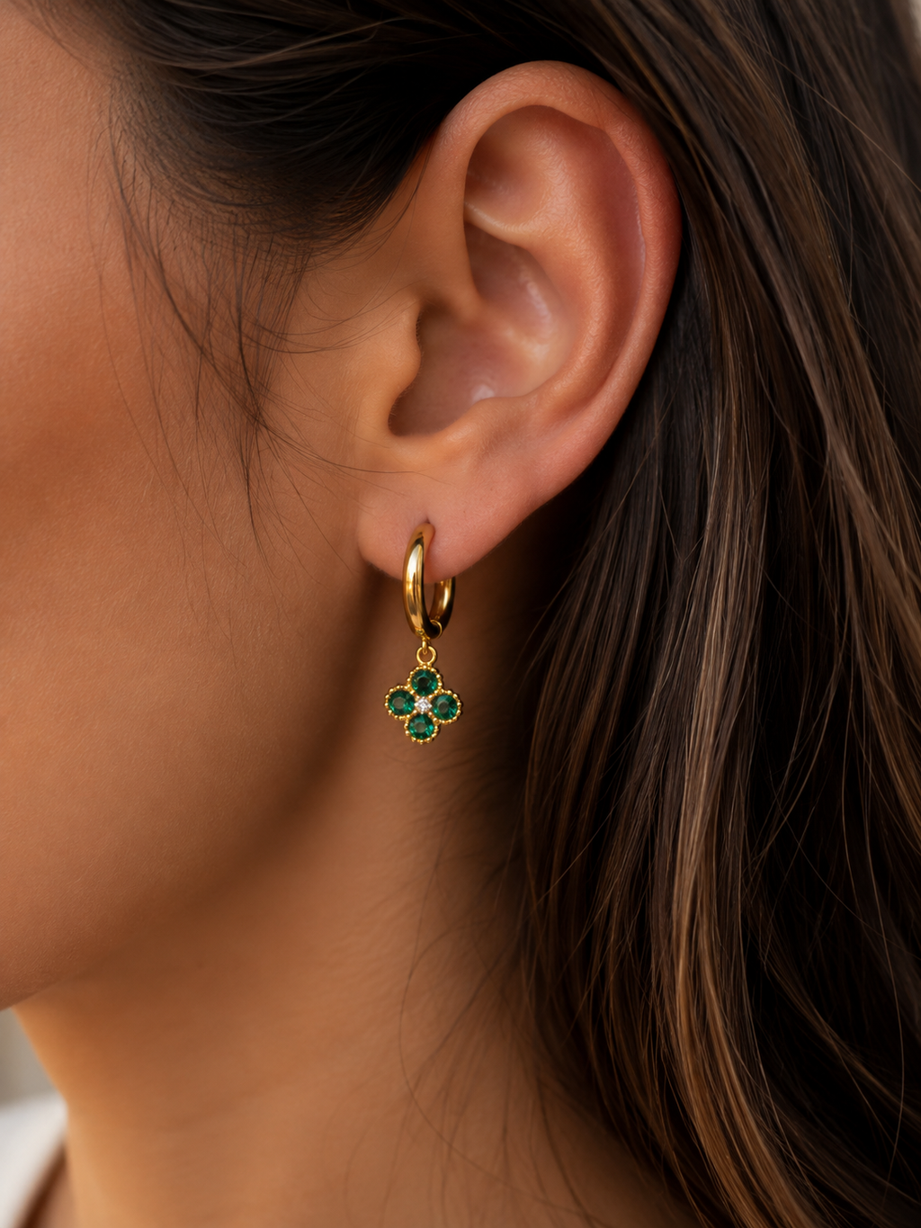Boucles d'oreilles Trèfle dorées vertes portées par une femme